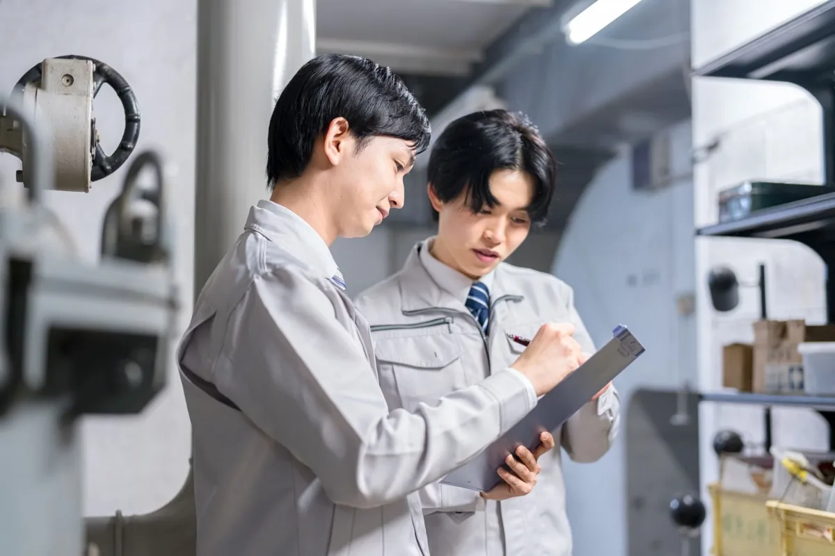 現場で先輩社員から作業の説明を受ける新人